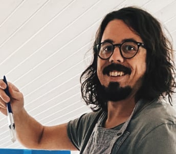 a guy in his late 30s wearing glasses, a beard and a smile